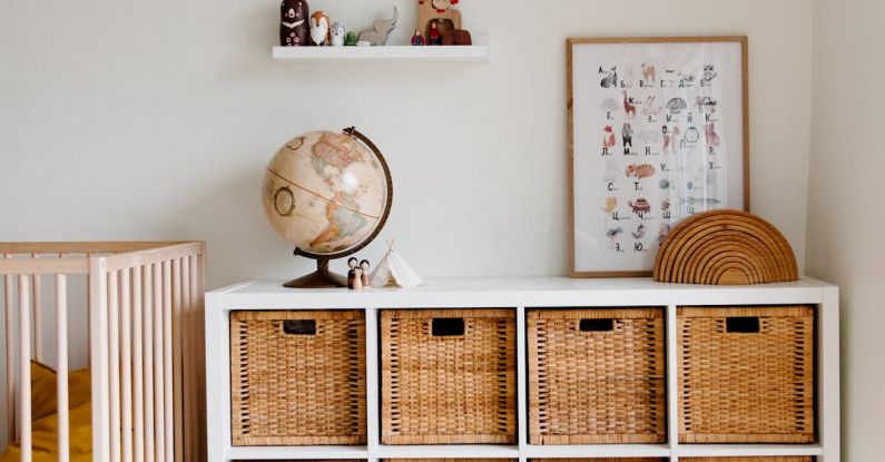 Child's Room - Comfortable bed with toys globe and paintings placed on wooden cabinet with wicker boxes and soft white rug with toy house on floor